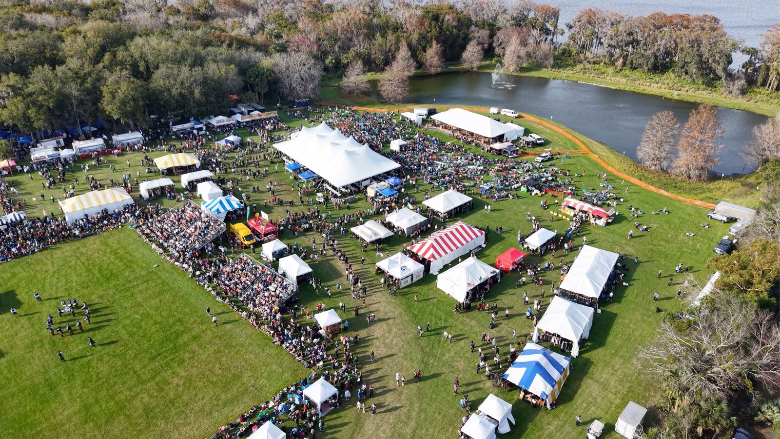 Oblique aerial view of festival tents and crowds at the 2025 Central Florida Highland Games beside a lake in Winter Springs